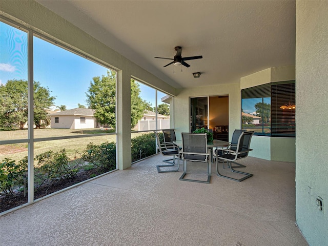 sunroom / solarium featuring a ceiling fan and outdoor dining area