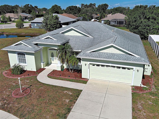 ranch-style house featuring an attached garage, roof with shingles, driveway, stucco siding, and a residential view