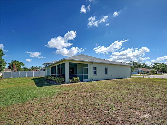 back of property featuring a sunroom and stucco siding