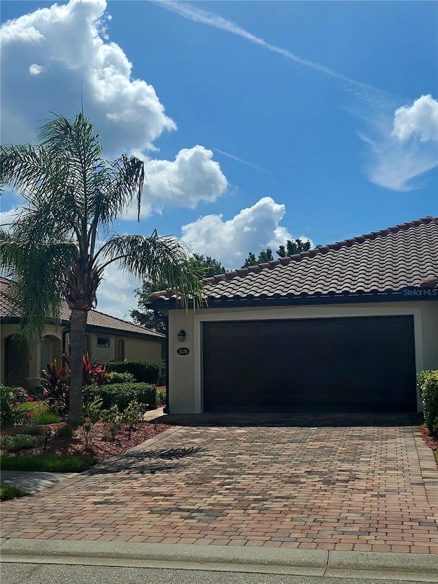 20188 Tesoro Dr, Venice, FL 34293 - view of front facade featuring decorative driveway, a tile roof, and an attached garage