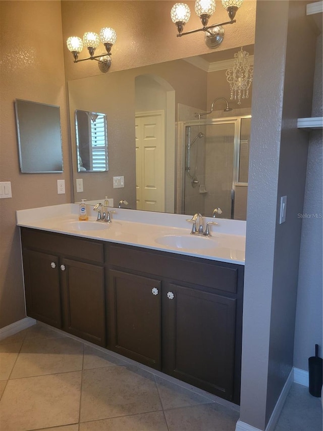 20188 Tesoro Dr, Venice, FL 34293 - bathroom featuring a chandelier, double vanity, a stall shower, tile patterned floors, and ornamental molding