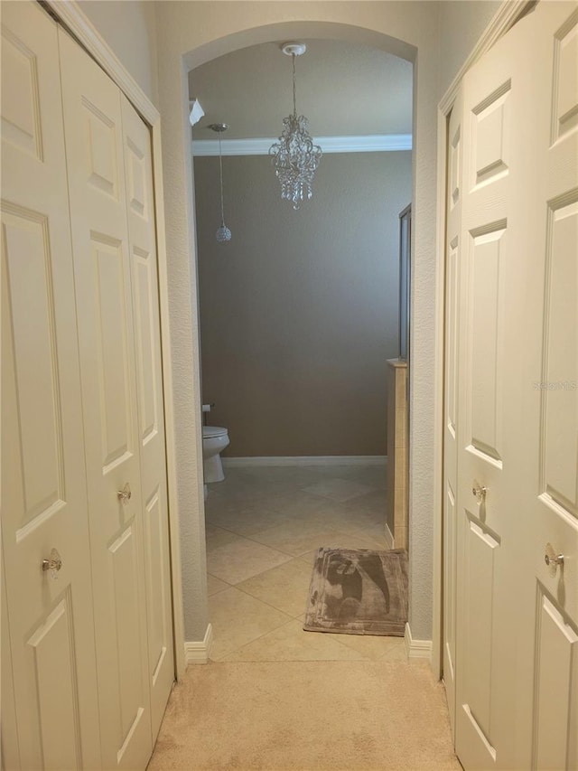 20188 Tesoro Dr, Venice, FL 34293 - hall with arched walkways, a chandelier, light colored carpet, and ornamental molding