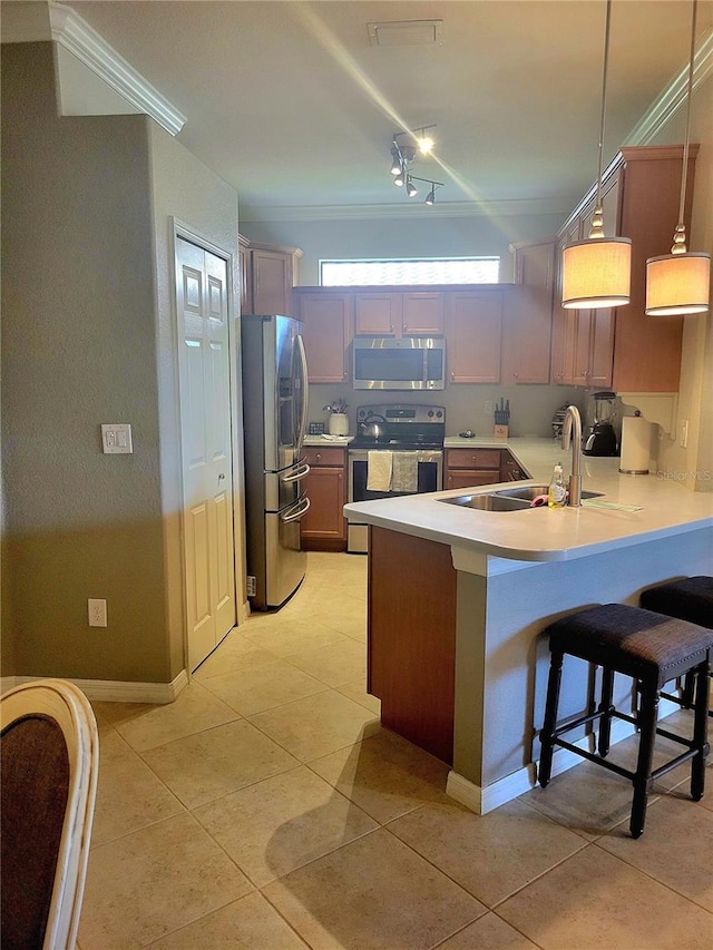 20188 Tesoro Dr, Venice, FL 34293 - kitchen with stainless steel appliances, a peninsula, light countertops, light tile patterned floors, and ornamental molding