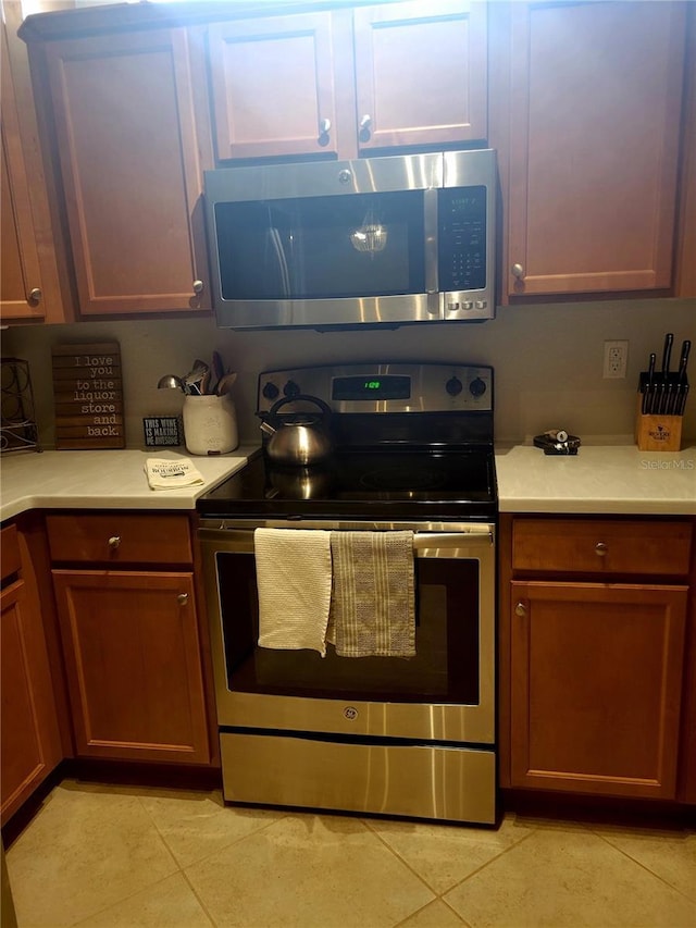 20188 Tesoro Dr, Venice, FL 34293 - kitchen with stainless steel appliances, light tile patterned flooring, and light countertops