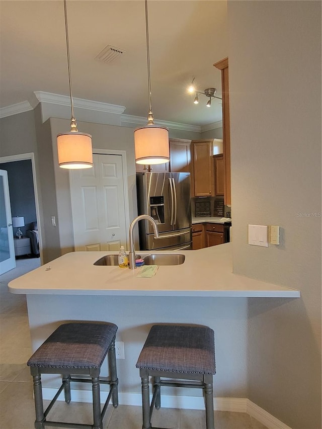 20188 Tesoro Dr, Venice, FL 34293 - kitchen featuring stainless steel fridge with ice dispenser, ornamental molding, a kitchen breakfast bar, light countertops, and a peninsula