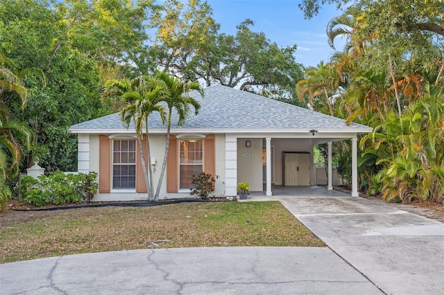 1629 Siesta Dr, Sarasota, FL 34239 - single story home featuring a shingled roof, concrete driveway, a front lawn, stucco siding, and an attached carport