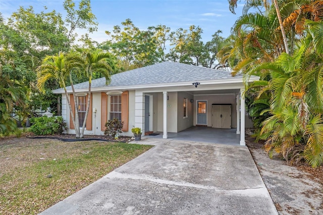 1629 Siesta Dr, Sarasota, FL 34239 - single story home with stucco siding, roof with shingles, a front lawn, concrete driveway, and an attached carport
