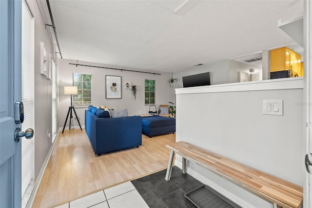 1629 Siesta Dr, Sarasota, FL 34239 - living area featuring visible vents, baseboards, tile patterned flooring, and a textured ceiling