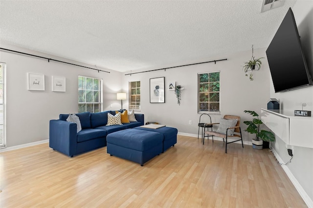 1629 Siesta Dr, Sarasota, FL 34239 - living room with plenty of natural light, light wood finished floors, visible vents, and a textured ceiling