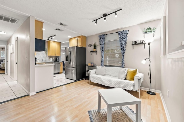 1629 Siesta Dr, Sarasota, FL 34239 - living area with rail lighting, visible vents, and light wood-type flooring