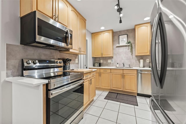 1629 Siesta Dr, Sarasota, FL 34239 - kitchen with a sink, light countertops, appliances with stainless steel finishes, light brown cabinetry, and light tile patterned flooring