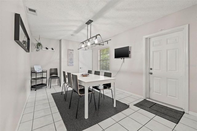 1629 Siesta Dr, Sarasota, FL 34239 - dining room with baseboards, a chandelier, light tile patterned floors, a textured ceiling, and visible vents