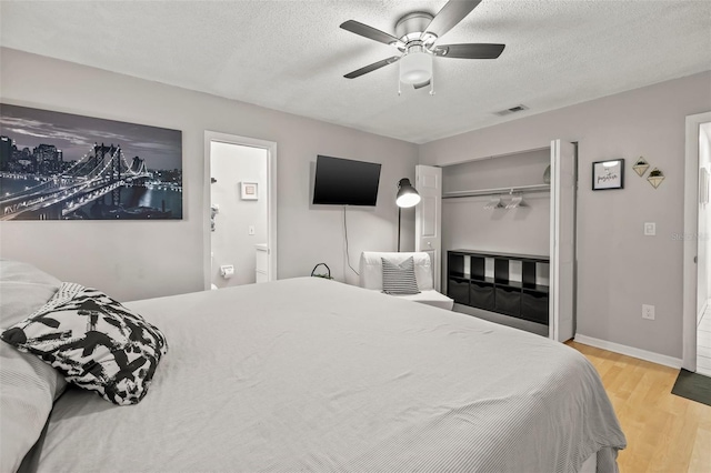 1629 Siesta Dr, Sarasota, FL 34239 - bedroom featuring a closet, a textured ceiling, a ceiling fan, visible vents, and wood finished floors