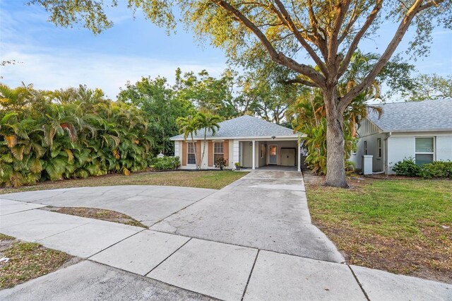 1629 Siesta Dr, Sarasota, FL 34239 - ranch-style home featuring roof with shingles, driveway, a front yard, and an attached carport