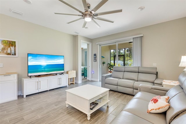 living area with wood tiled floors, ceiling fan, and baseboards