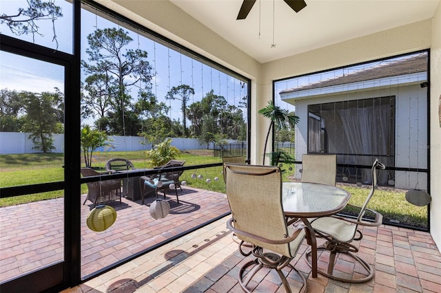 sunroom featuring outdoor dining space and ceiling fan