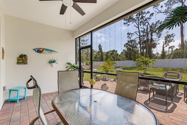 sunroom with ceiling fan and outdoor dining area