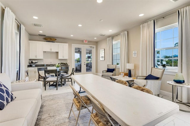 living area featuring light marble finish flooring, recessed lighting, healthy amount of natural light, french doors, and baseboards