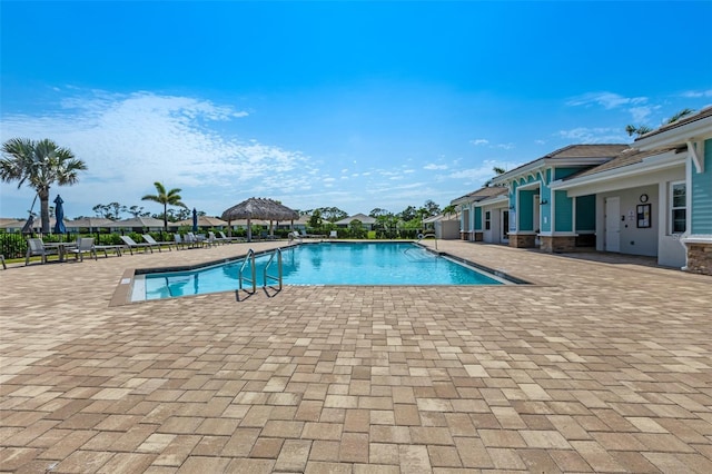 community pool with a gazebo and a patio area