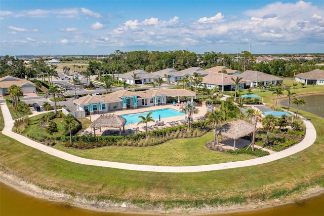 aerial view of residential area featuring a pool and a large body of water
