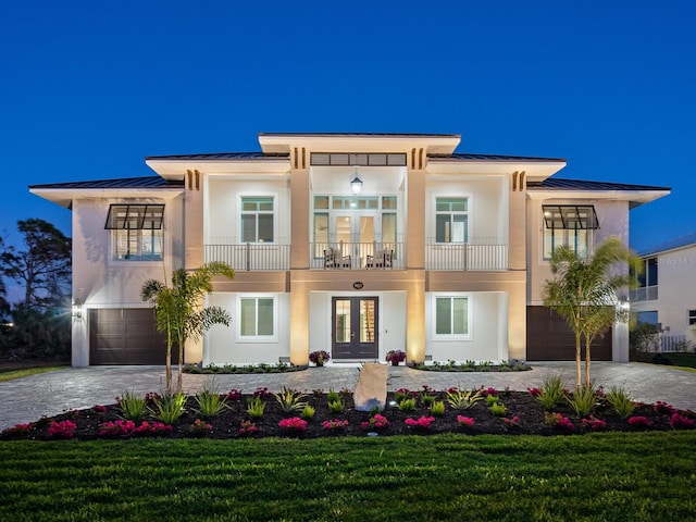 9810 Eagle Preserve Dr, Englewood, FL 34224 - view of front of house featuring a balcony, decorative driveway, french doors, a standing seam roof, and an attached garage