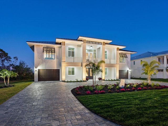 9810 Eagle Preserve Dr, Englewood, FL 34224 - view of front of home featuring a garage, a balcony, decorative driveway, stucco siding, and a standing seam roof