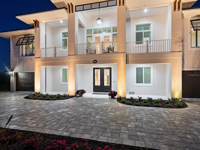 9810 Eagle Preserve Dr, Englewood, FL 34224 - exterior space with an attached garage, decorative driveway, stucco siding, and french doors