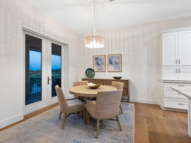 9810 Eagle Preserve Dr, Englewood, FL 34224 - dining room with baseboards, an inviting chandelier, and light wood-type flooring