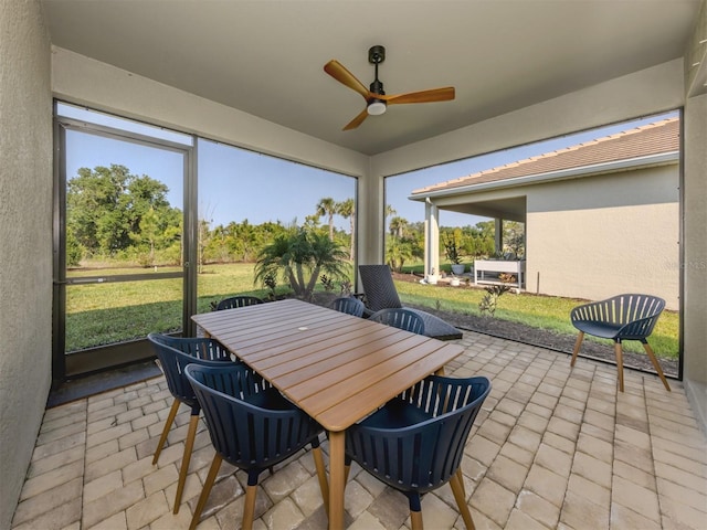 sunroom / solarium with ceiling fan and outdoor dining space