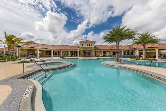 community pool featuring a community hot tub and a patio area
