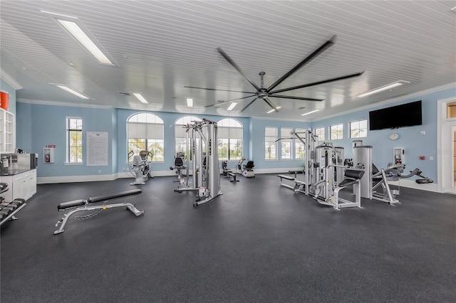 workout area with a wealth of natural light, baseboards, and ornamental molding