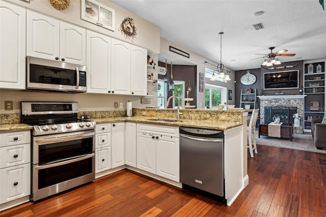 6824 283rd St E, Myakka City, FL 34251 - kitchen featuring stainless steel appliances, a sink, a peninsula, dark wood-type flooring, and open floor plan