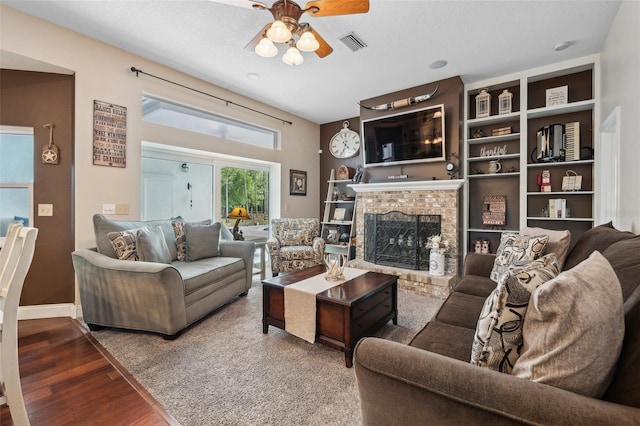6824 283rd St E, Myakka City, FL 34251 - living room featuring a ceiling fan, a fireplace, wood finished floors, and baseboards