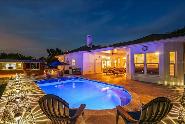 6824 283rd St E, Myakka City, FL 34251 - pool at twilight featuring a patio area, an outdoor living space, an outdoor pool, and a gazebo