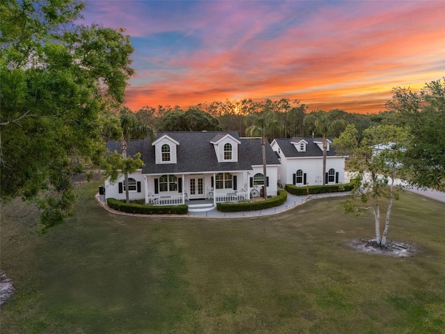 6824 283rd St E, Myakka City, FL 34251 - cape cod home featuring covered porch, a yard, french doors, and roof with shingles