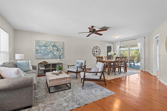 205 Cavallini Dr, Nokomis, FL 34275 - living area featuring wood finished floors, visible vents, a textured ceiling, and a ceiling fan