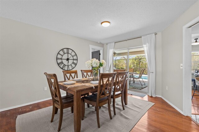 205 Cavallini Dr, Nokomis, FL 34275 - dining area featuring wood finished floors, a textured ceiling, and baseboards