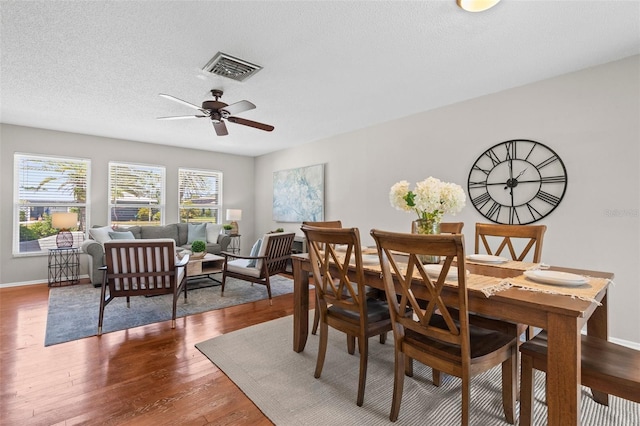 205 Cavallini Dr, Nokomis, FL 34275 - dining area with wood finished floors, visible vents, baseboards, a textured ceiling, and ceiling fan