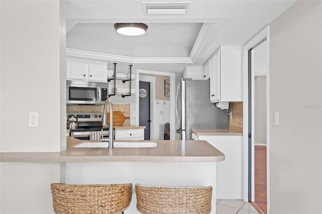 205 Cavallini Dr, Nokomis, FL 34275 - kitchen featuring white cabinets, stainless steel appliances, visible vents, a sink, and tasteful backsplash