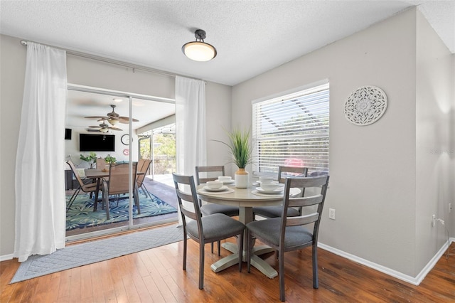 205 Cavallini Dr, Nokomis, FL 34275 - dining room featuring baseboards, a textured ceiling, and wood-type flooring