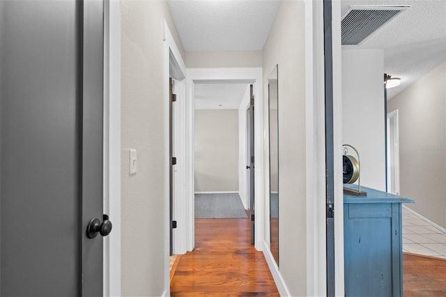 205 Cavallini Dr, Nokomis, FL 34275 - hall with a textured ceiling, wood finished floors, and visible vents