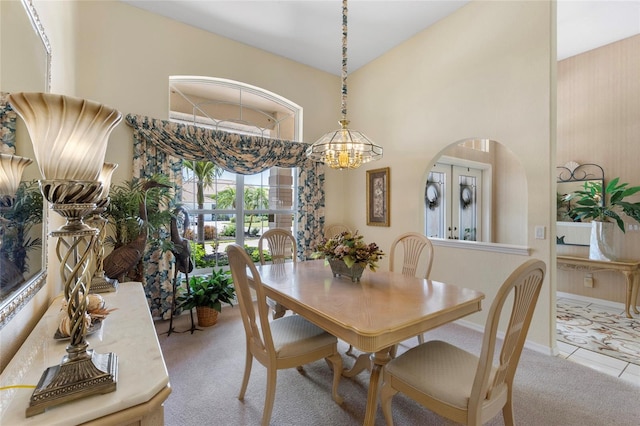 511 Governors Green Dr, Venice, FL 34293 - dining area featuring arched walkways, a high ceiling, carpet, and a notable chandelier