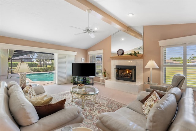 511 Governors Green Dr, Venice, FL 34293 - carpeted living area with a tile fireplace, a wealth of natural light, a ceiling fan, and vaulted ceiling with beams