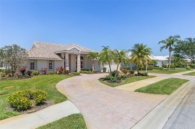 511 Governors Green Dr, Venice, FL 34293 - mediterranean / spanish house with a tiled roof, a front yard, curved driveway, and stucco siding