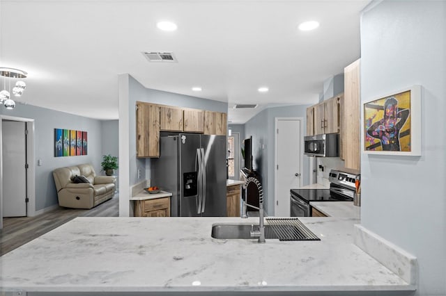 3355 Roslyn Rd, Venice, FL 34293 - kitchen with light stone counters, stainless steel appliances, wood finished floors, visible vents, and a sink