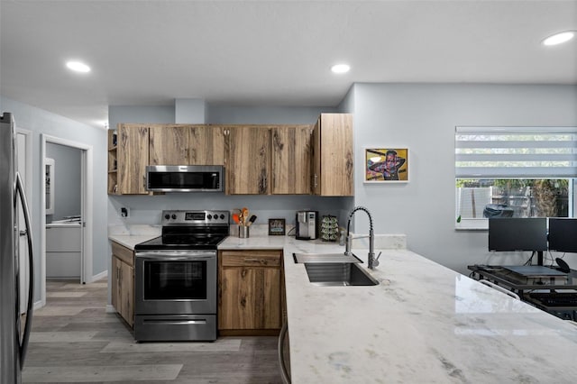 3355 Roslyn Rd, Venice, FL 34293 - kitchen with light wood-style floors, brown cabinetry, appliances with stainless steel finishes, and a sink