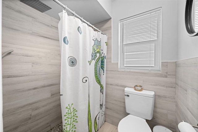 3355 Roslyn Rd, Venice, FL 34293 - full bathroom featuring a tile shower, toilet, and wainscoting