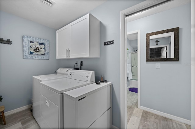 3355 Roslyn Rd, Venice, FL 34293 - laundry room featuring light wood finished floors, baseboards, visible vents, independent washer and dryer, and cabinet space