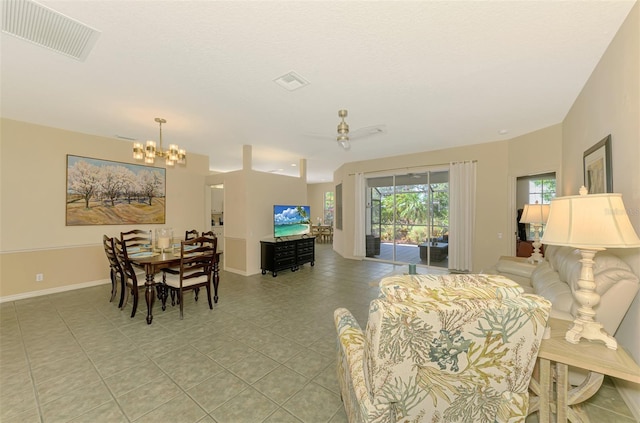 living area with light tile patterned floors, a notable chandelier, visible vents, and baseboards