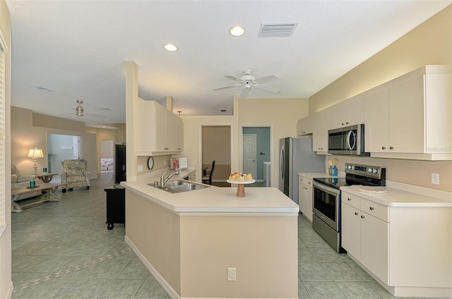 kitchen with a sink, ceiling fan, stainless steel appliances, light countertops, and visible vents